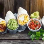 Colorful and appetizing breakfast burrito with eggs, bacon, and cheese