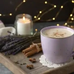 A steaming cup of Lavender Moon Milk in a cozy ceramic mug, garnished with dried lavender and cinnamon.