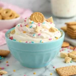 A creamy, colorful Funfetti Dip served in a bowl, topped with rainbow sprinkles.