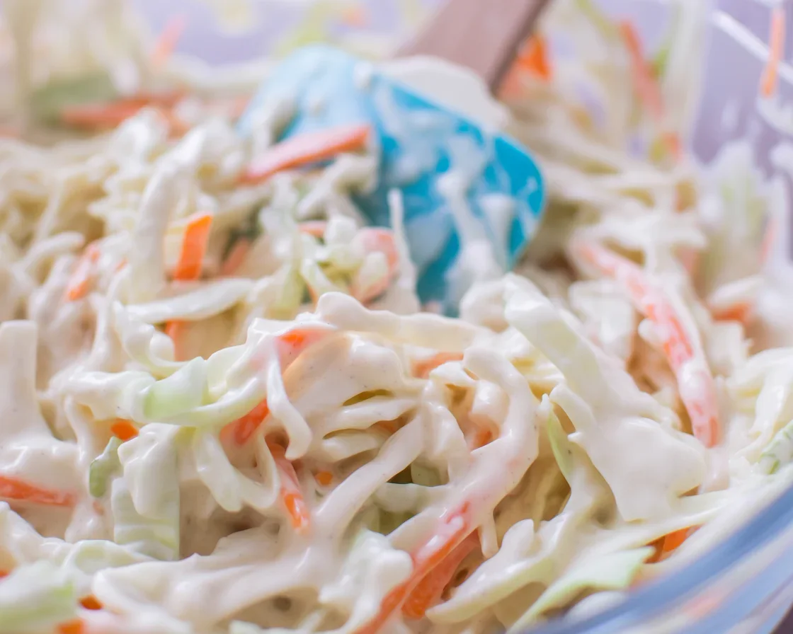 Bowl of creamy coleslaw made with fresh cabbage, carrots, and tangy dressing.