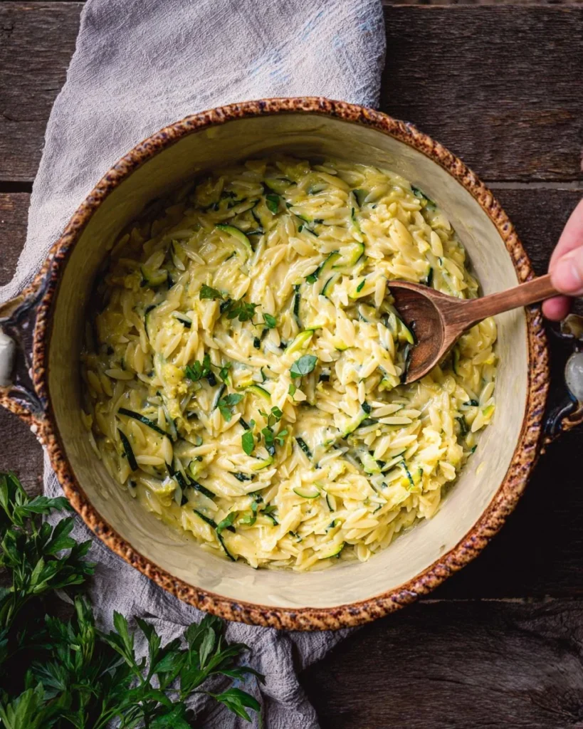 Creamy lemon orzo with zucchini and cheese in a bowl