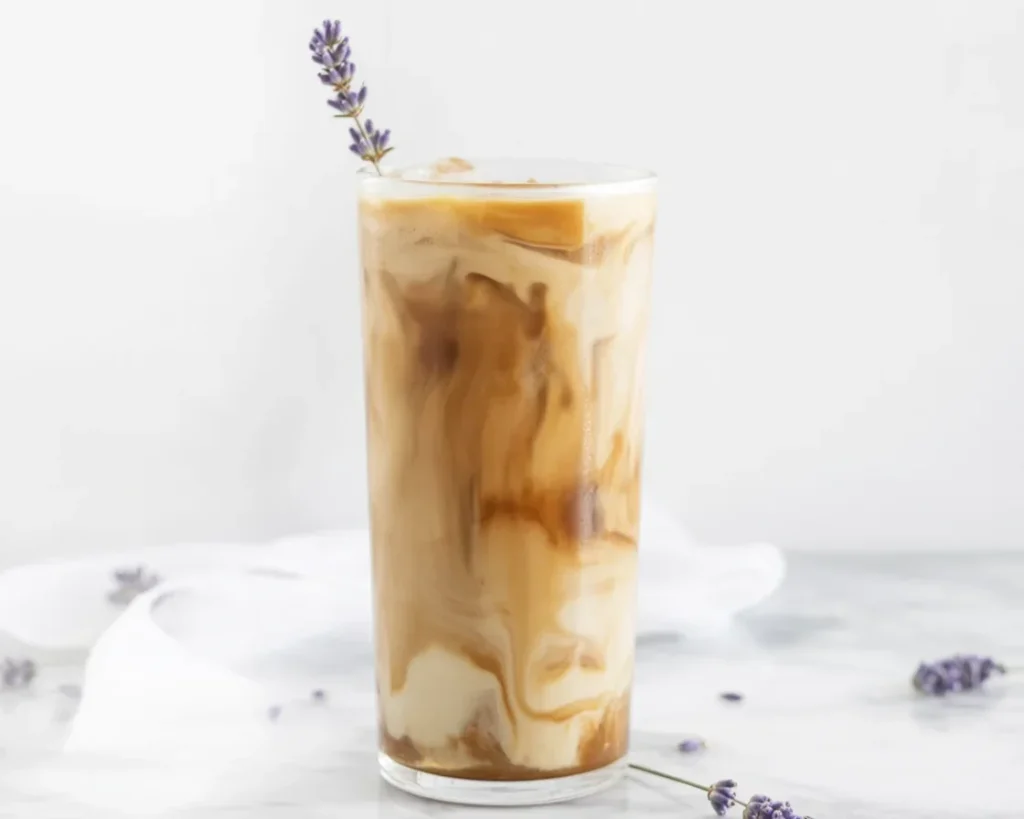 Vanilla Bean Lavender Cold Brew Latte in a glass with lavender flowers