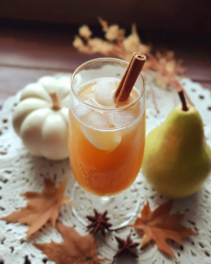 Refreshing spiced pear tea fizz drink topped with fresh pear slices.