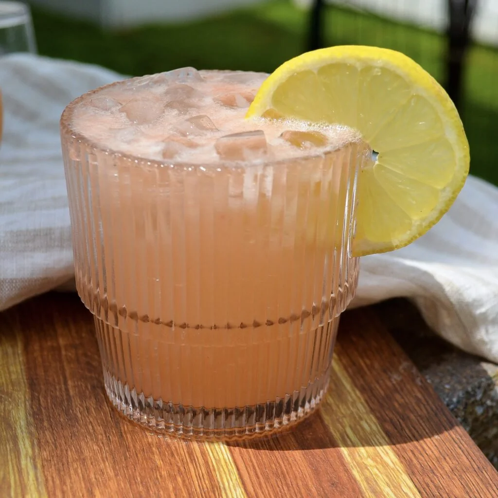 Refreshing Virgin Paloma mocktail with grapefruit and lime garnished with fresh herbs