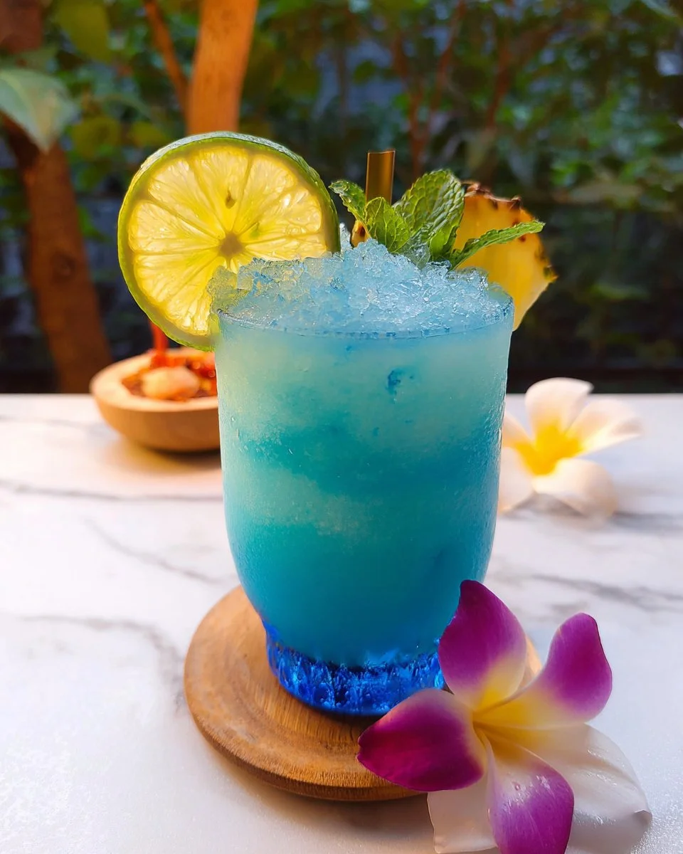 Blue Hawaii mocktail served in a tropical glass with garnishes