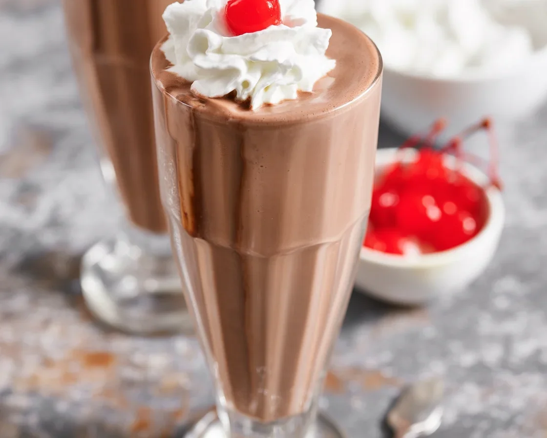 Delicious homemade chocolate milkshake topped with whipped cream and chocolate syrup.