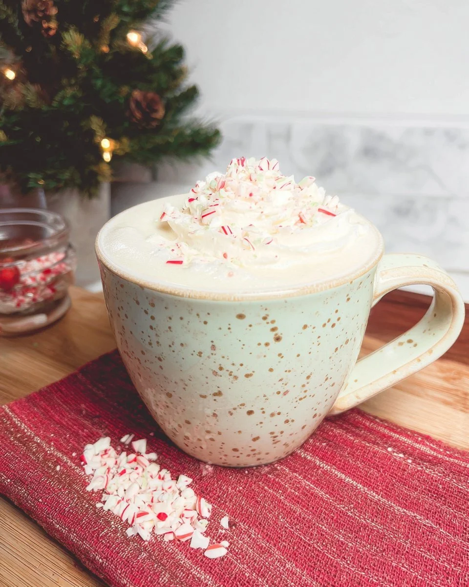 Delicious peppermint white hot chocolate topped with whipped cream and peppermint candy.
