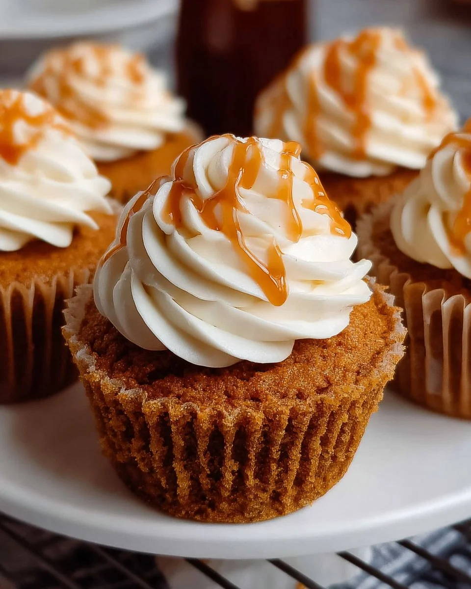 Delicious pumpkin cupcakes with creamy frosting displayed on a rustic table