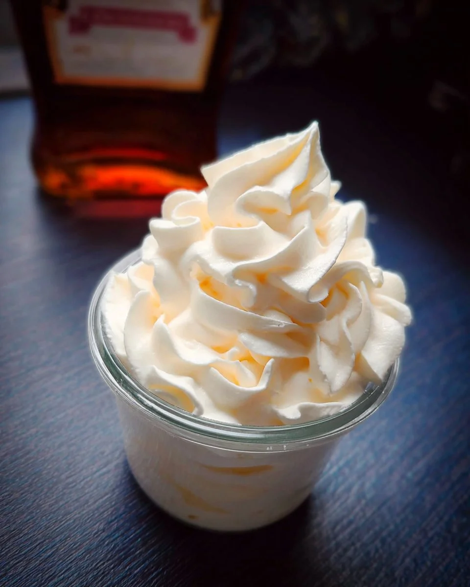 Bowl of zesty orange-flavored whipped cream topped with an orange slice