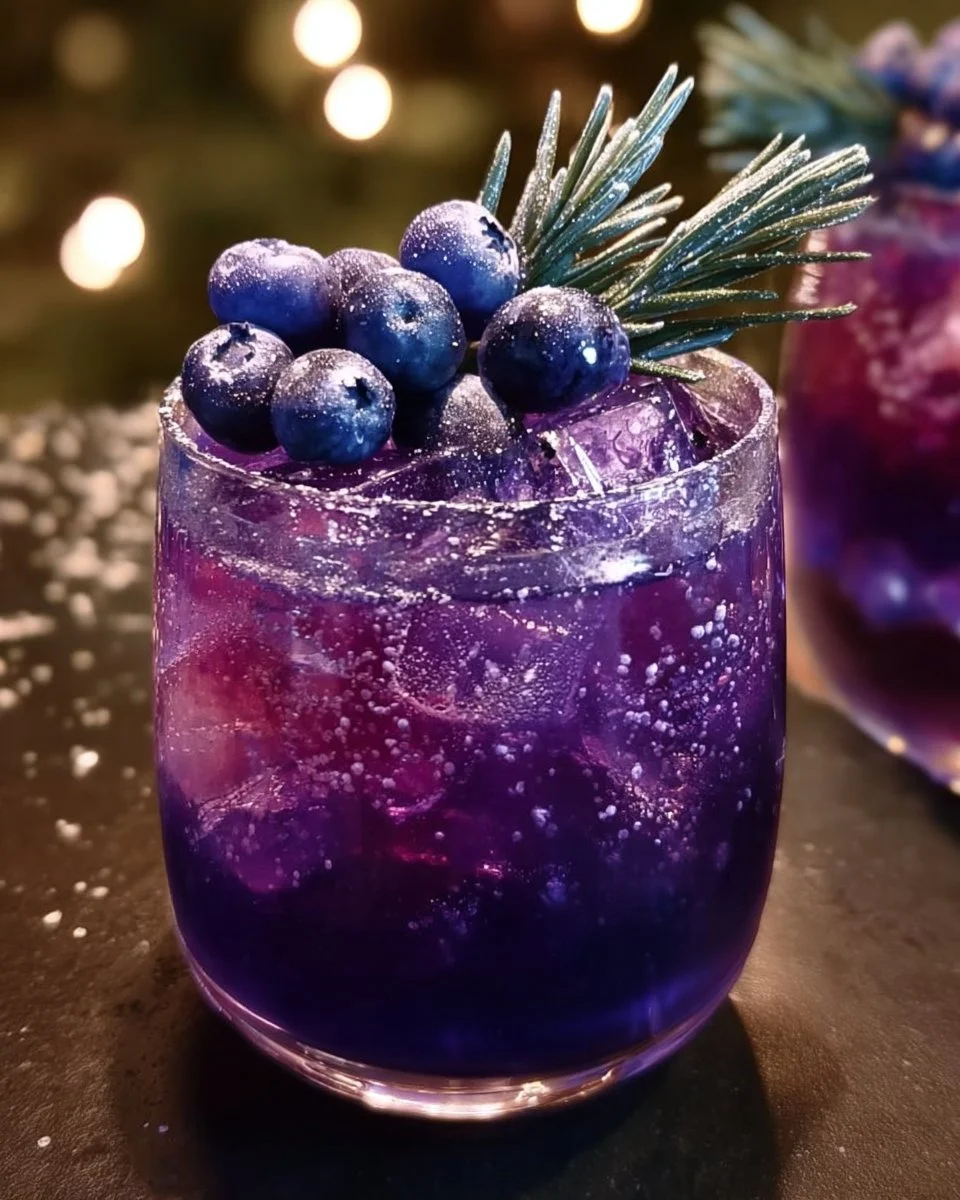 Glass of Christmas Blueberry Amethyst Punch with fresh blueberries and amethyst color.