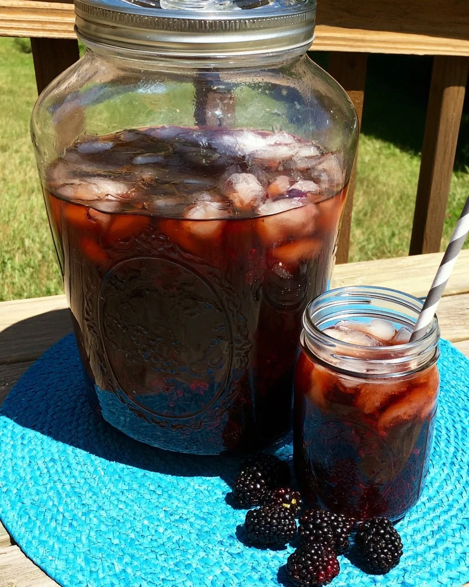 A glass of refreshing Blackberry Sun Tea infused with fresh blackberries.
