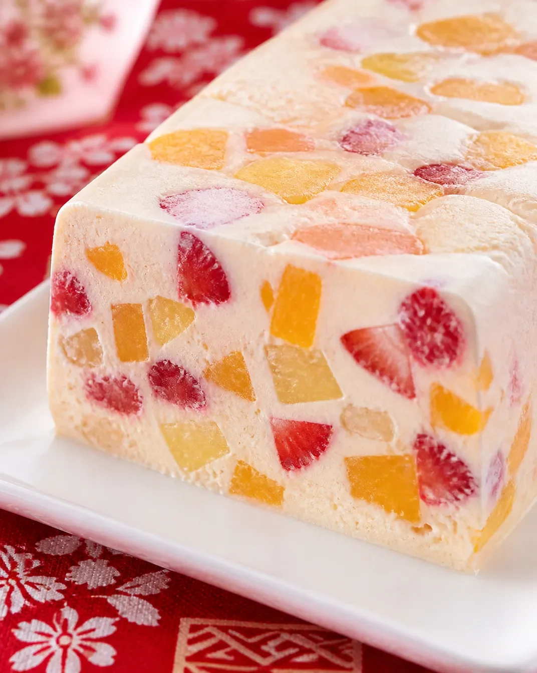 A colorful frozen fruit salad served in a bowl with various fruits.