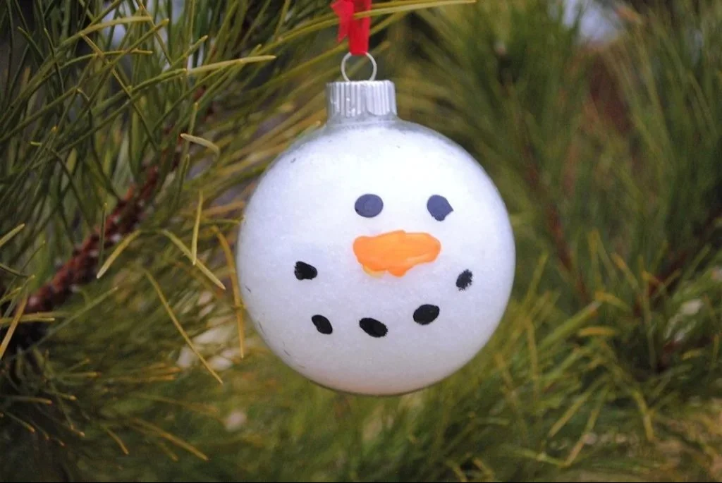 Colorful snowman ornament craft made by kids for holiday decoration.