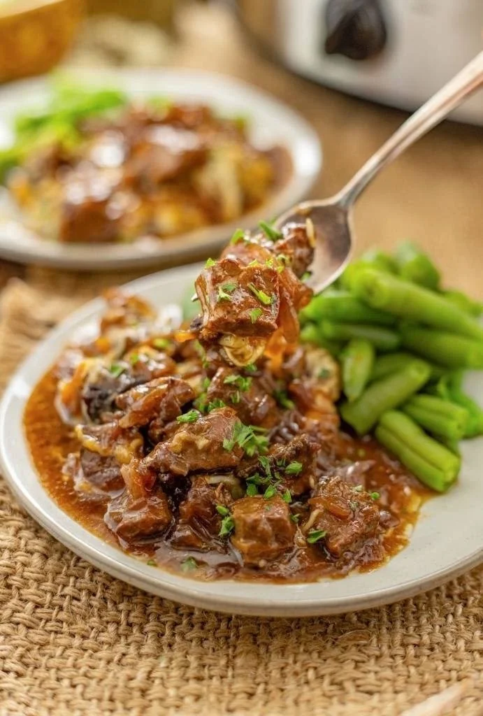 Crock Pot French onion beef tips served with a side of creamy mashed potatoes