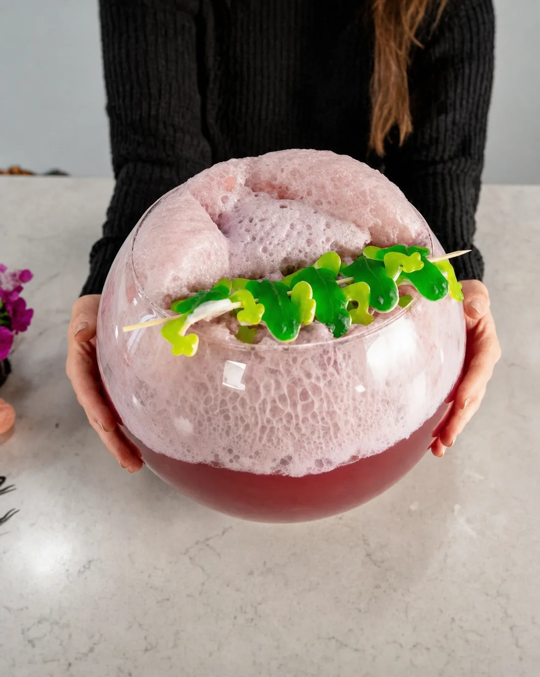 Bowl of fizzy Hocus Pocus Punch with Halloween decorations