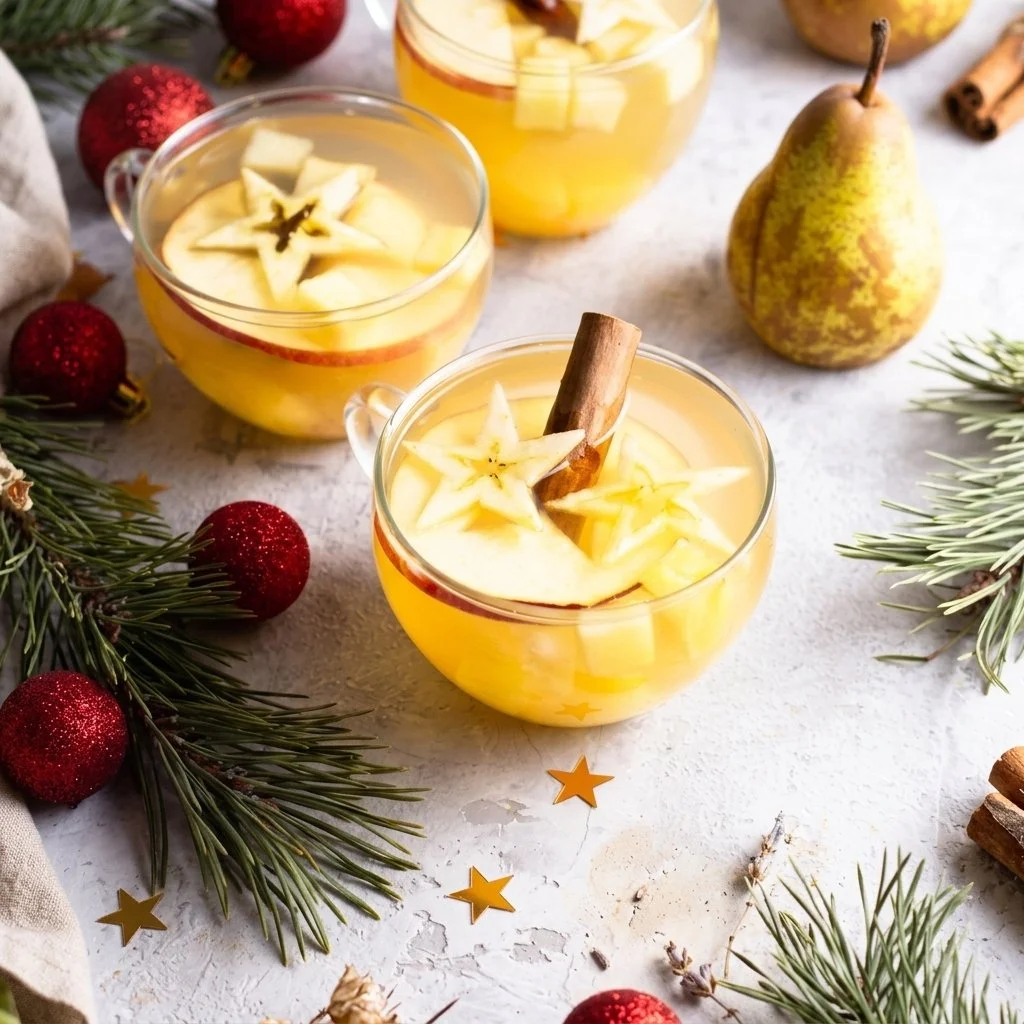 A bowl of Holiday Hot Fruit Punch filled with colorful fruits and spices.