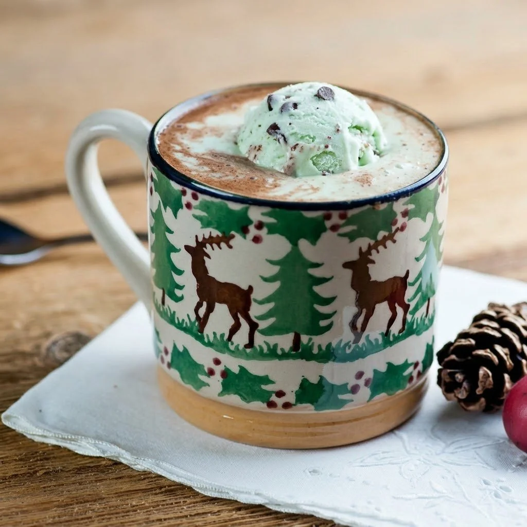 Mint chocolate chip hot cocoa floats topped with whipped cream and mint.